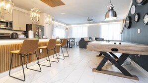 Une cuisine moderne dotée d’un bar, d’un espace repas et d’une table de billard.