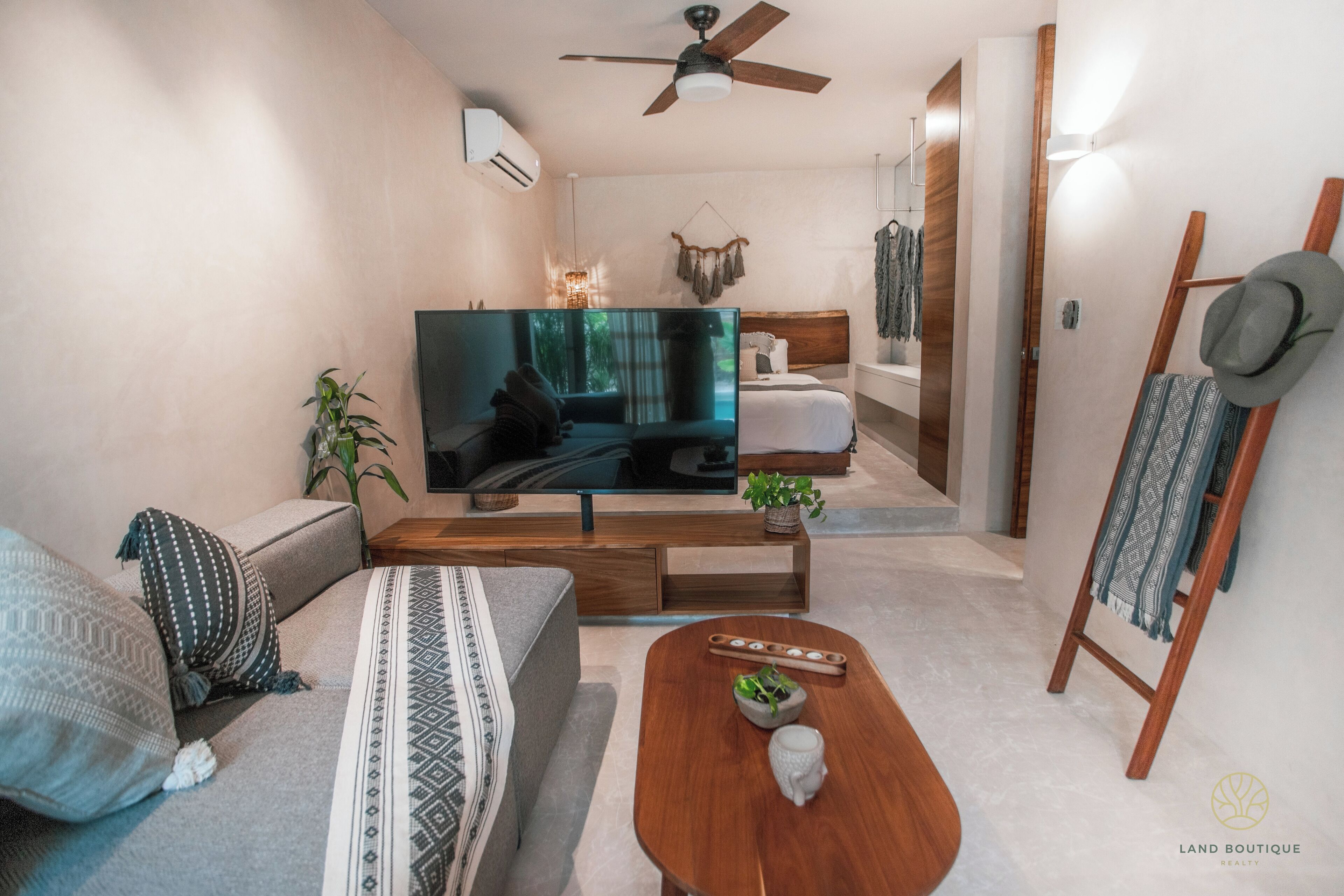A modern living room with a flat-screen TV, a sofa, a coffee table, and a wooden side table.