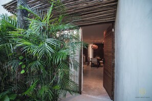 A modern building with a wooden pergola and lush greenery. - Jungle hideway 3BR /plunge pool (Tulum)