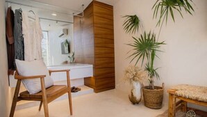 Une salle de bain moderne avec un meuble-lavabo en bois, un grand miroir et une plante suspendue.