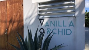 La entrada de un edificio con una puerta de madera y un cartel que dice 'Vanilla Orchid'.