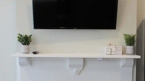 A modern living room with a flat-screen TV mounted above a white mantelpiece. - ★MODERN 1BR GREAT Location Downtown! W/D Parking!★ (Albany)