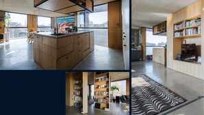 Una cucina moderna con isola centrale, mobili in legno e un'ampia finestra con vista sulla città.