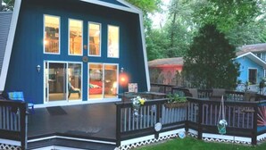 A blue house with a deck and a small garden. - Chalet by the Bay Charming Beach Getaway (Lewes)