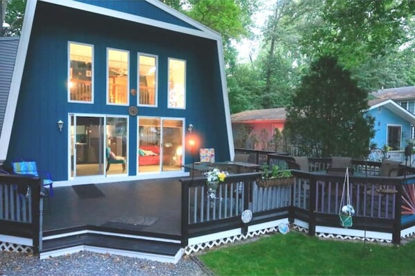 A blue house with a deck and a small garden.