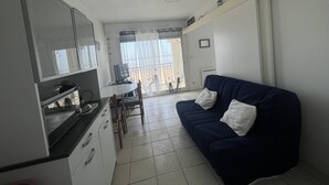 A compact living space with a kitchenette, a dining area, and a sofa. - Appartement vue sur mer (Châtelaillon-Plage)