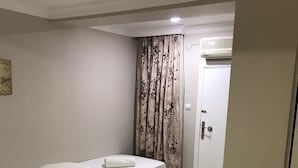 A bedroom with two beds, a door, and an air conditioning unit. - Lavinya Pansiyon (Kusadasi)