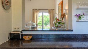 A kitchen with a toaster, a glass cake server, and a basket on the counter. - 3 bed + villa near Gordes with air-con, pool and stunning views over the Luberon (Cabrières-d'Avignon)