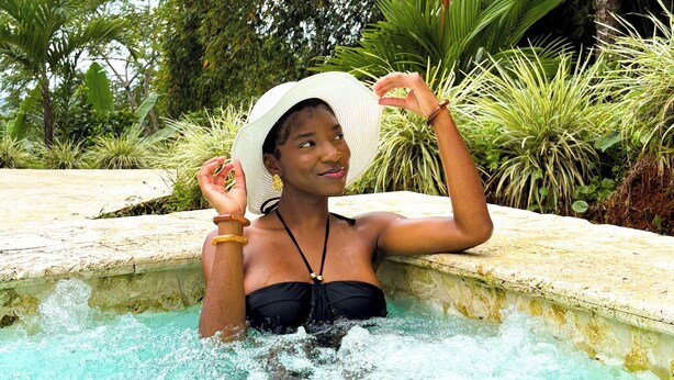 Une personne dans un bain à remous, entourée d’une végétation luxuriante.