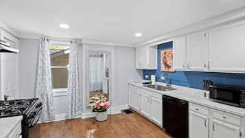 A kitchen with white cabinets, a black stove, and a dishwasher.