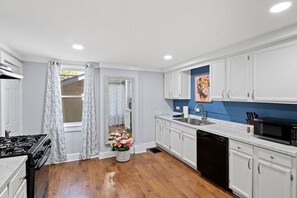 A kitchen with white cabinets, a black stove, and a dishwasher. - Explore Ithaca | Near Colleges | State Parks (Ithaca)