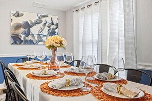 A dining table set for a meal with plates, cutlery, and wine glasses, surrounded by chairs. - Explore Ithaca | Near Colleges | State Parks (Ithaca)