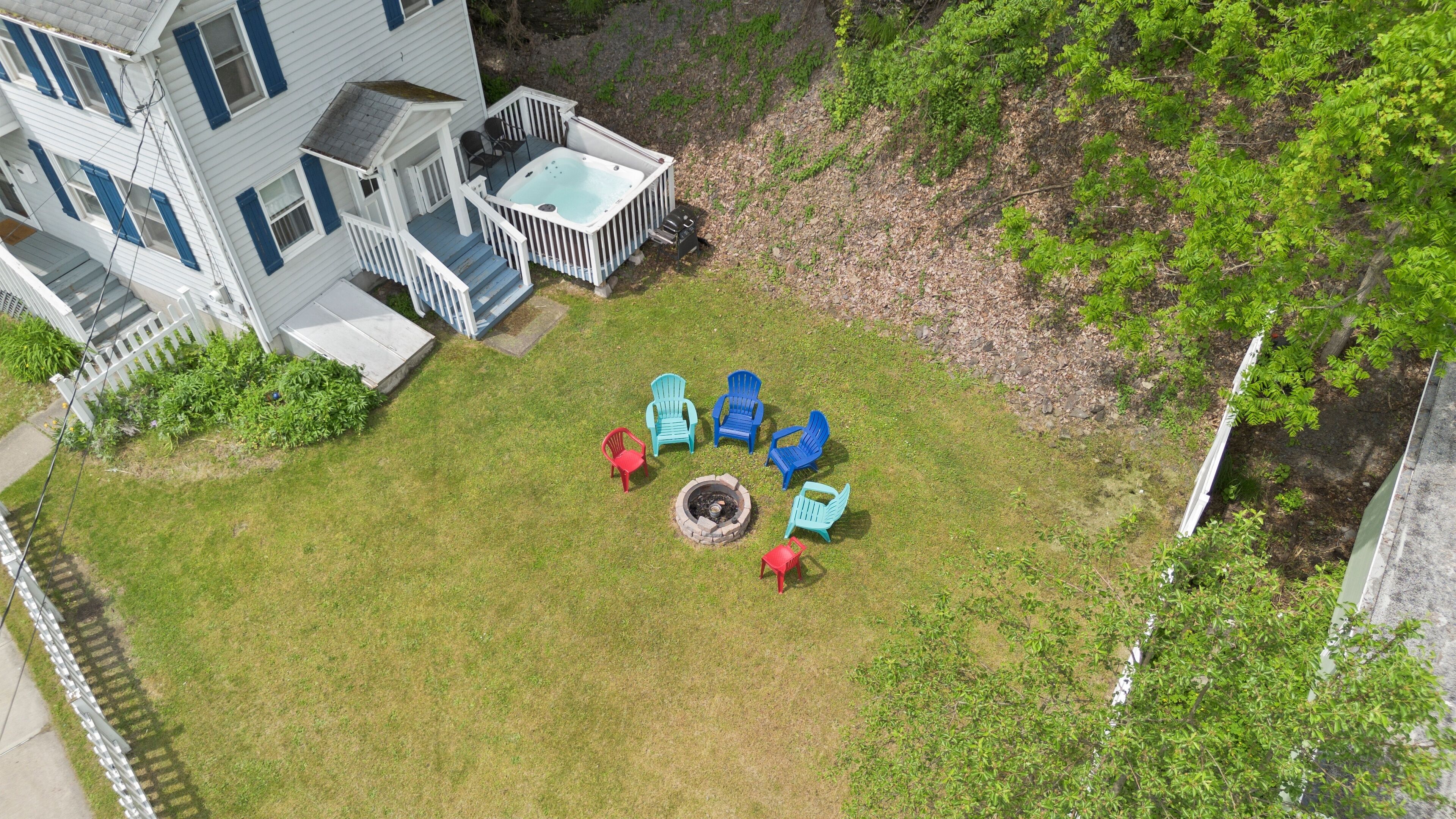 Un jardin avec un jacuzzi, un foyer extérieur et un espace salon extérieur.