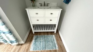 A bathroom with a white vanity, a sink, and a mirror. - Beachy Escape for 2 Fun in The Sun Endless Charm! (Galveston)