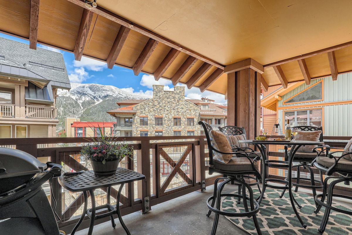 Un balcon avec coin salon extérieur, un barbecue et une vue sur la montagne.