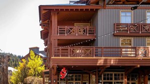 A multi-story building with balconies, a sign for a restaurant, and a view of trees. - Luxury Slope & Village Views, Deck, Steps to Lifts (Frisco)