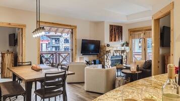 Un interior moderno con comedor, asientos, chimenea y televisor.