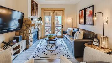 Una sala de estar acogedora con chimenea, televisor, sofá y mesa de centro.