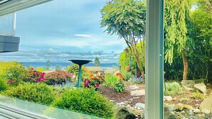 A garden view with a birdbath, colorful flowers, and a clear sky. - 1400sft Spacious SeaView Retreat & Garden surround (Federal Way)