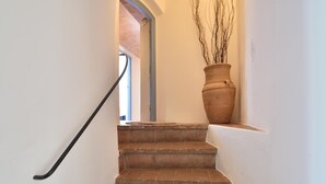 Un escalier avec une rampe, menant à une porte.