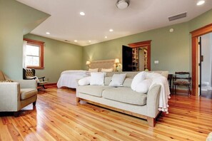 Relax in this serene space with a large bed, comfortable sofa, and stylish chair.