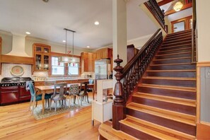 Kitchen with stove, ample counter space, and wooden staircase leading to an upper level.