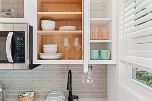 Fridge, microwave, coffee/tea maker, cookware/dishes/utensils