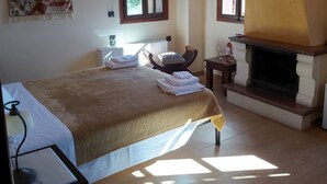 Een slaapkamer met een bed, een open haard en een raam.