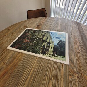 A round wooden table with a framed photograph of a building.