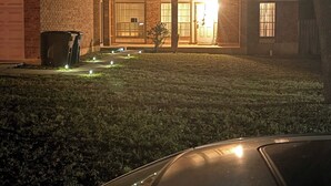 Een woonhuis met garage, voortuin en oprit.