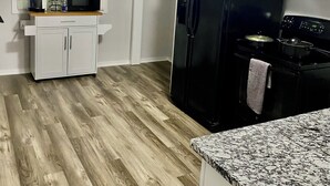 A modern kitchen with a black refrigerator, a microwave, and a stove. There is a white cabinet and a countertop with a granite top. - Beautiful & Stylish 2 BR & 2.5 Baths 10min downtown, 5min Lexington Med Center (Columbia)