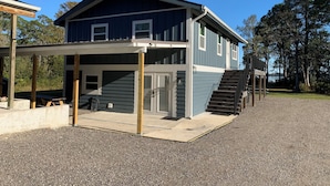 Ein zweistöckiges Haus mit einer Veranda und einer Treppe, die zu der oberen Etage führt.