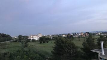 A view of a residential area with houses, greenery, and a clear sky.
