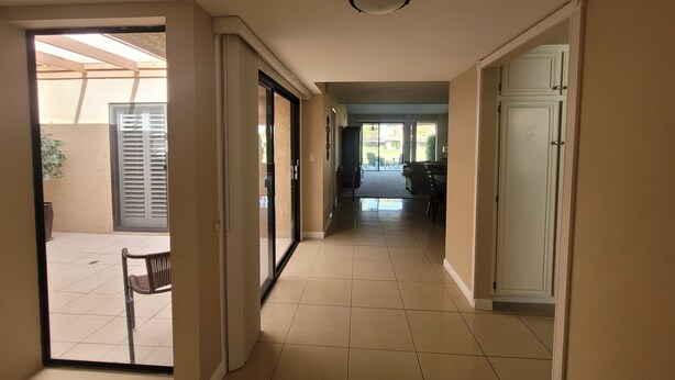 A hallway with a sliding glass door leading to an outdoor patio area.