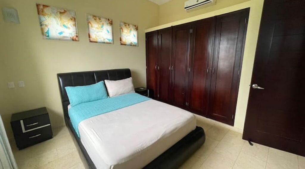 Une chambre à coucher avec un lit, une armoire et une table de chevet.