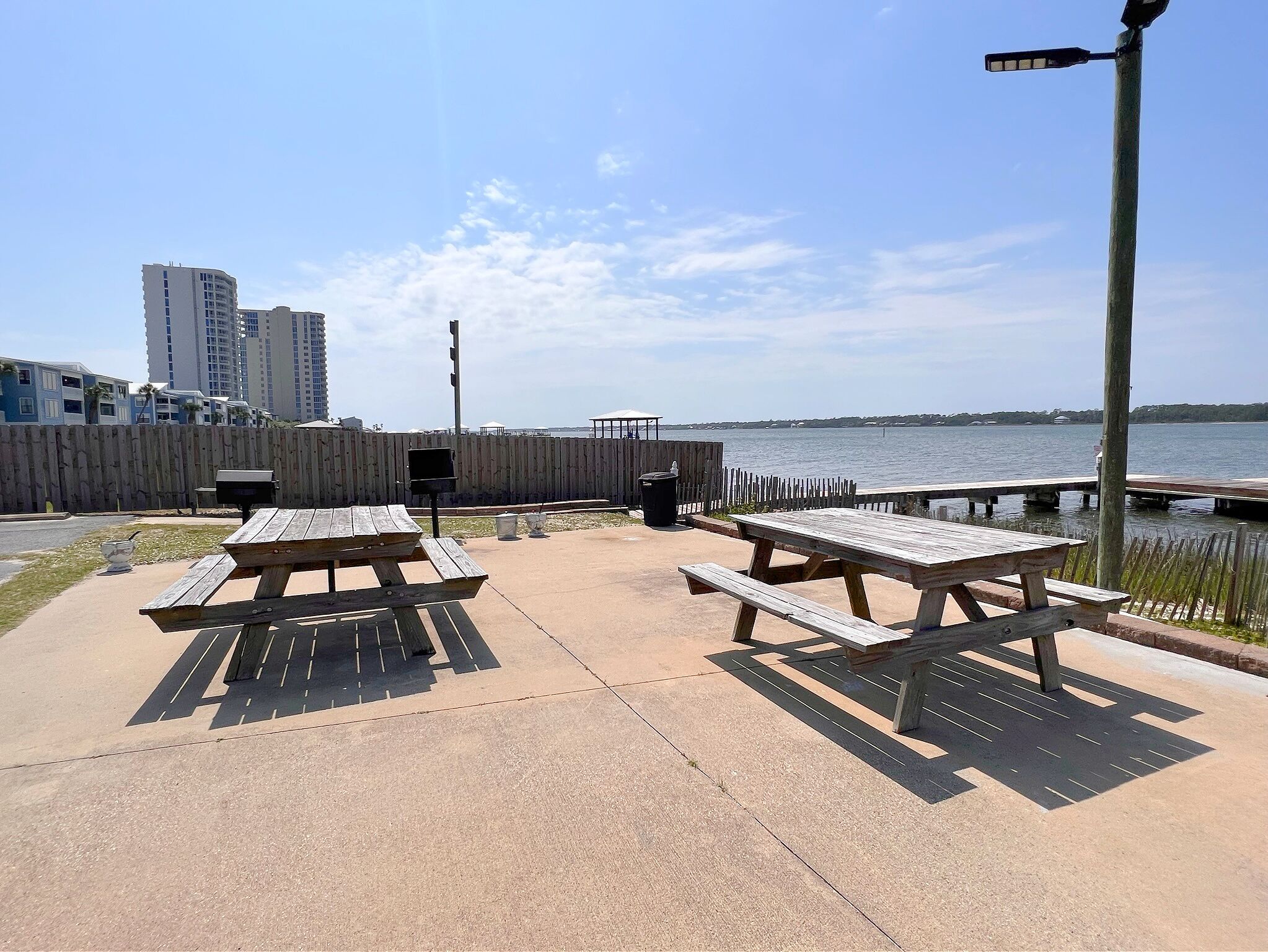 Une terrasse extérieure avec des tables de pique-nique et une vue sur l’eau.