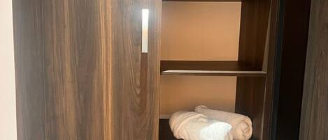 Ein Schrank mit mehreren Fächern, darunter ein Kleiderbereich und Regale.