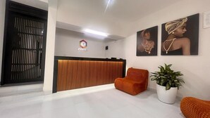 A reception area with a modern design, featuring a reception desk, seating area, and artwork on the walls. - Hotel Zuriel Boutique (Cartagena)