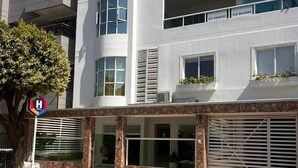 A modern hotel with a white facade, multiple balconies, and a visible hotel sign. - Hotel Zuriel Boutique (Cartagena)