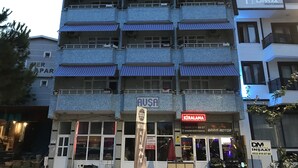 A multi-story building with balconies, a sign for 'KIRALAMA BARIS MOTOR', and a 'JOEY MOTEL' sign. - Joey Pansiyon (Marmara)