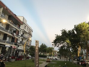A multi-story building with balconies and a sign that reads "Güzel InSAAT". - Joey Pansiyon (Marmara)