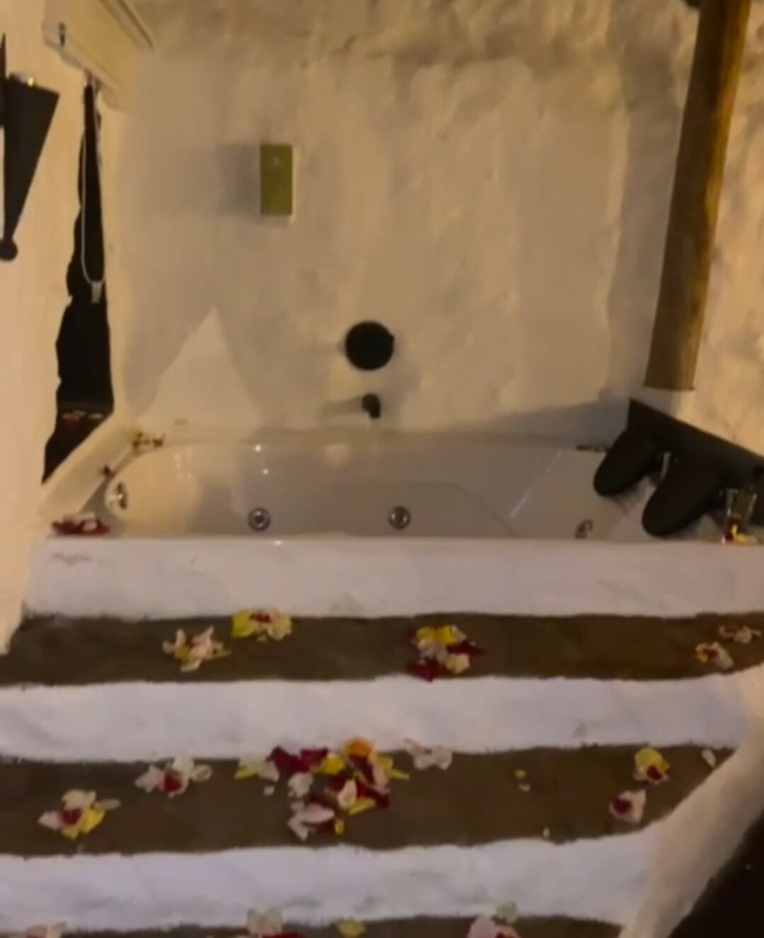 Une baignoire ornée de pétales de rose sur les marches.