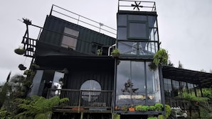 Un edificio moderno con fachada de vidrio, varios niveles y zonas de estar al aire libre.