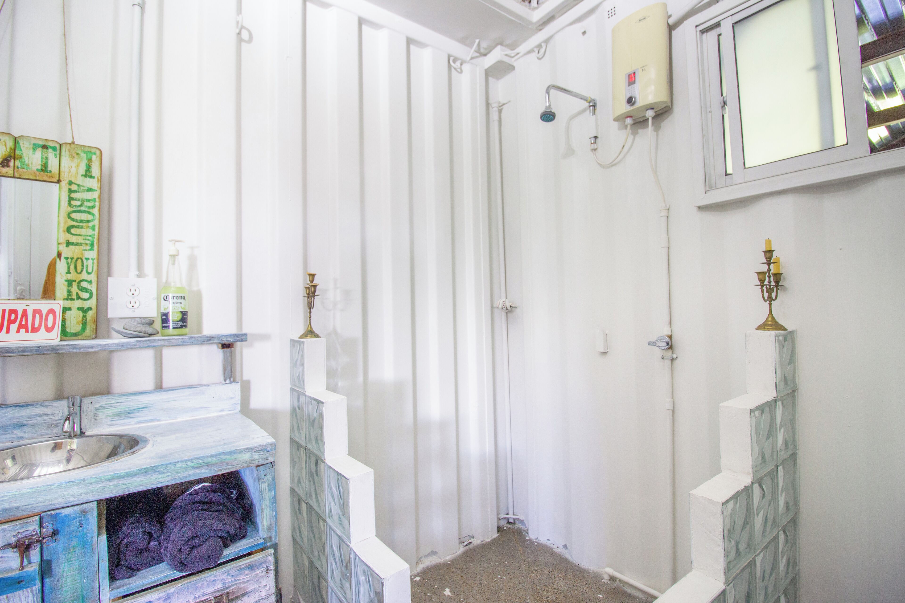 A bathroom with a shower, a sink, and a mirror.