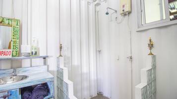 A bathroom with a shower, a sink, and a mirror.