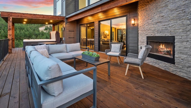 A modern outdoor deck with a sofa, chairs, and a fireplace. - Pet-Friendly Game Retreat for Families and Groups (Broken Bow)