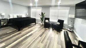Una habitación de hotel moderna con una cama, un escritorio, una silla y una planta en maceta.