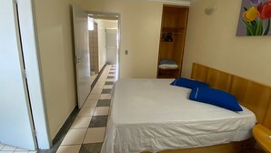 Une chambre d’hôtel avec un lit, une armoire et un tableau au mur.