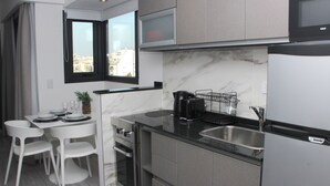 A compact kitchen with a built-in oven, a coffee maker, and a sink. - In House BA - Le Coq (Buenos Aires)