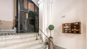 Eine Marmortreppe mit einer schwarzen Tür und einem Blumentopf.